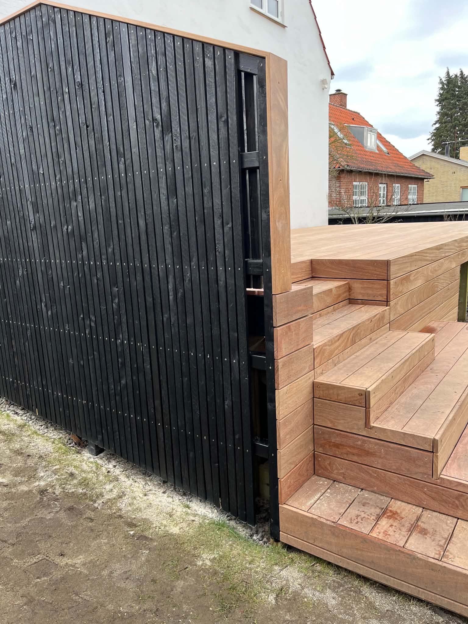 Terrasse i hårdttræ med trin op til huset